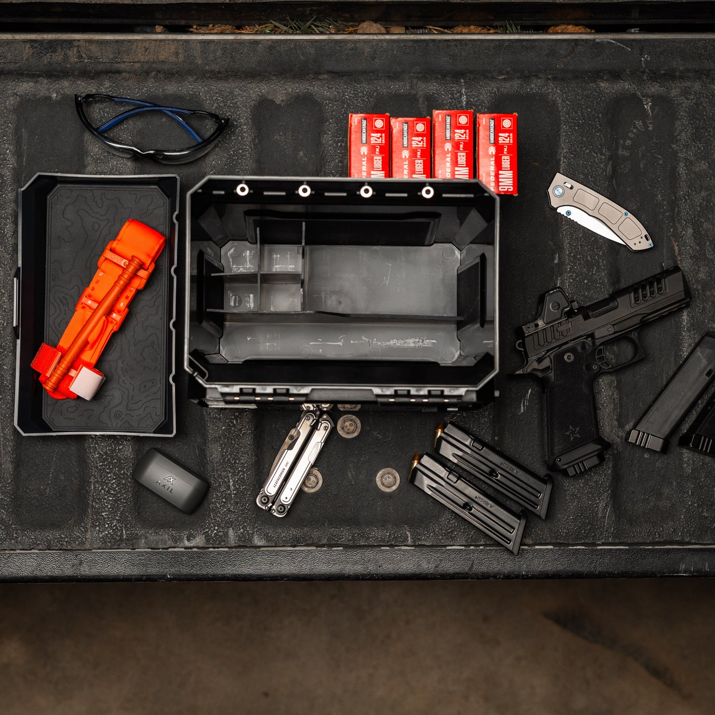 UCAN utility storage box with mechanical locking system organizing range gear and everyday carry items on table